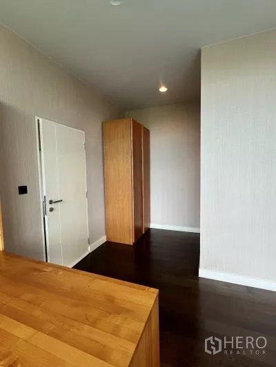 独立式住宅 出租在Bang Kapi, Bangkok - 二楼走廊，木地板与浅色墙面，独立木衣柜。