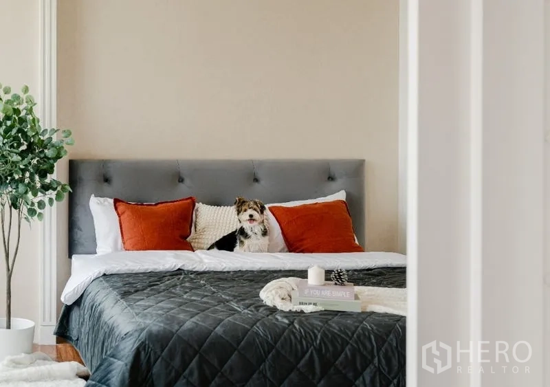 คอนโด ขาย - เตียงคิงไซส์พร้อมหมอนตกแต่งในห้องนอนโทนอบอุ่น