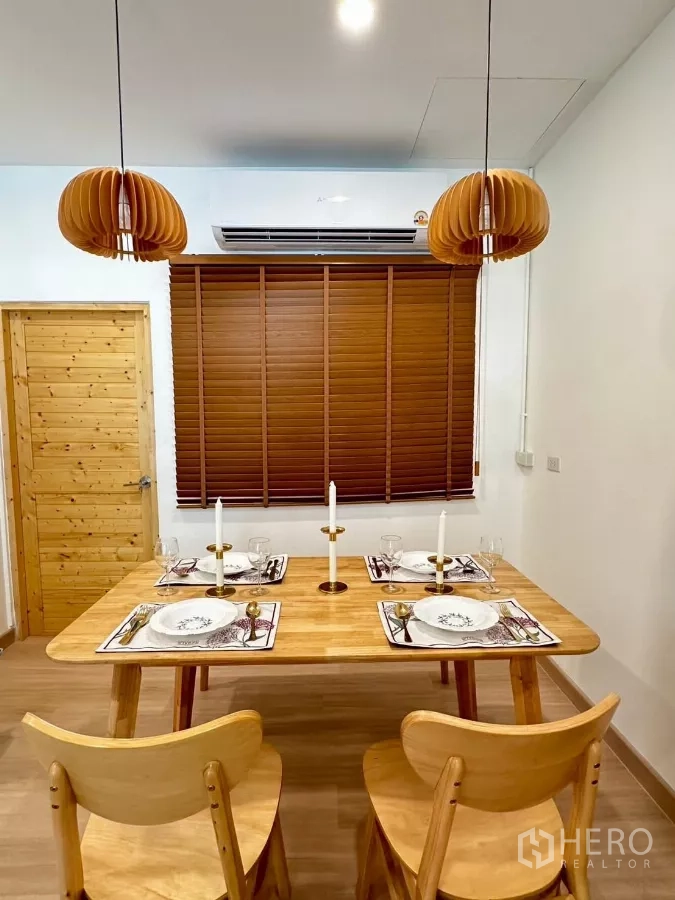 ทาวน์เฮาส์ ให้เช่าในBang Phli, Samut Prakan - ภาพใกล้ของโต๊ะอาหารจัดเซ็ต พร้อมโคมแขวนลายไม้บรรยากาศอบอุ่น