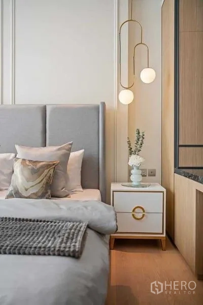 公寓 出租或出售在Khlong Toei, Bangkok - 床头柜、灰色床头板与现代吊灯的近景。