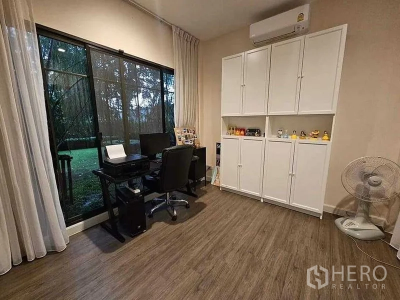บ้าน ขายในBang Kruai, Nonthaburi - ห้องทำงานชั้นล่าง เห็นวิวสวนผ่านหน้าต่างบานใหญ่ ตู้บิลท์อินสีขาวและโต๊ะทำงาน
