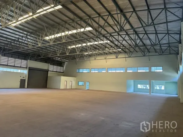 โรงงาน ให้เช่าในChon Buri - ภายในโกดังมีประตูม้วน หน้าต่าง และส่วนออฟฟิศเชื่อมต่อ