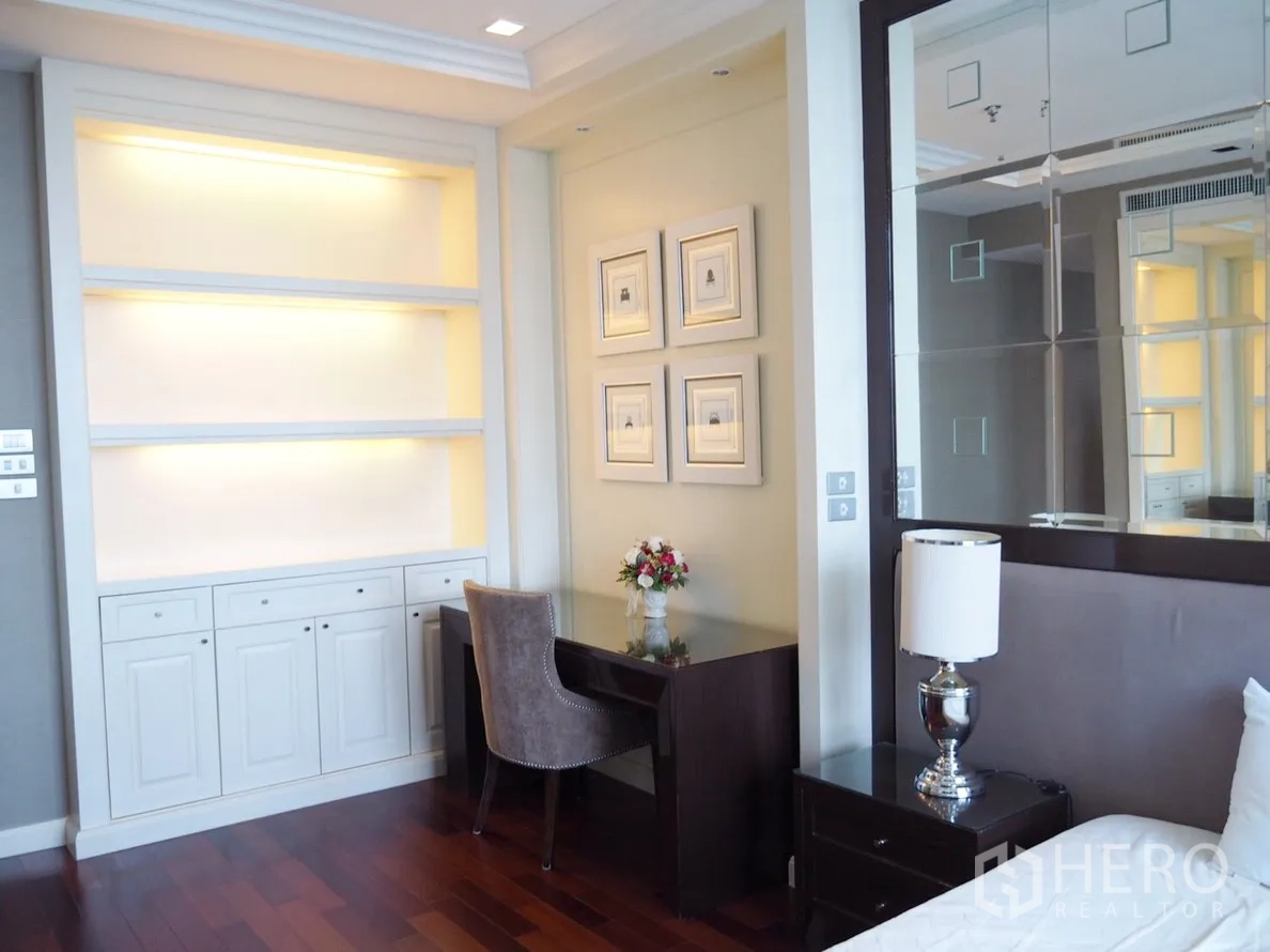 Condominium for rent in Pathum Wan, Bangkok - Bedroom workspace with built‑in illuminated shelves, study desk and framed artwork.