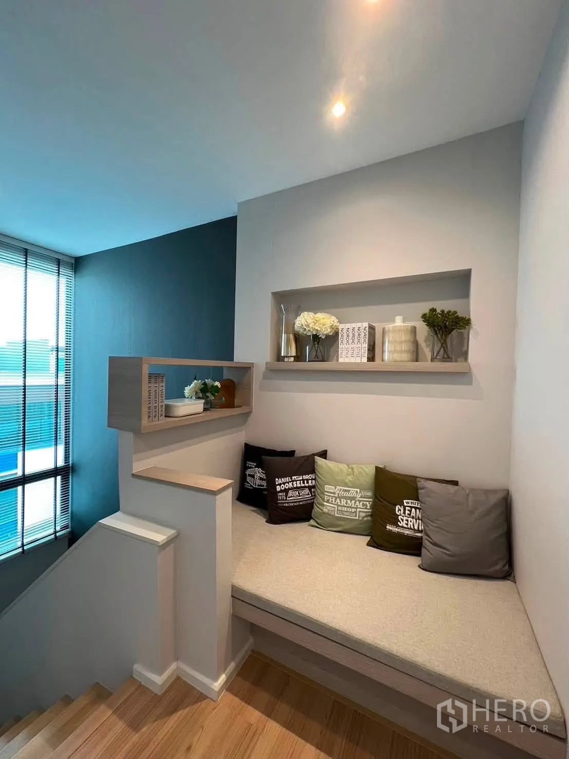 Townhouse for rent in Saphan Sung, Bangkok - Stair landing reading nook with cushioned bench and display shelves.