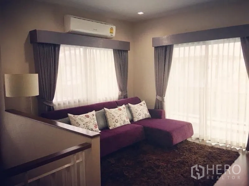 บ้าน ขาย - พื้นที่นั่งเล่นชั้นบน โซฟาสีม่วง หน้าต่างใหญ่ และเครื่องปรับอากาศ