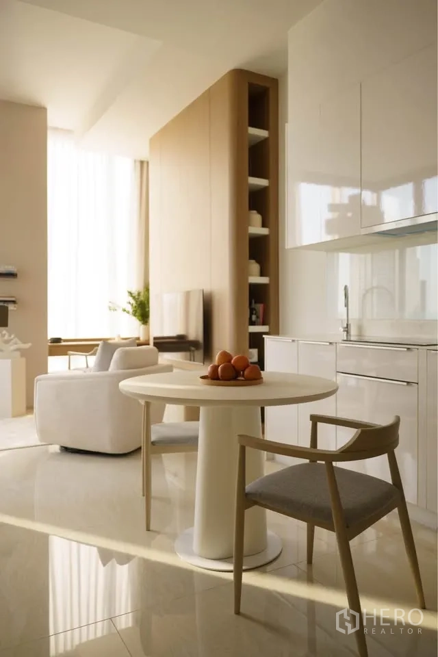 Condominium for rent in Bang Rak, Bangkok - Open-plan kitchenette with glossy cabinets next to dining table and living area.