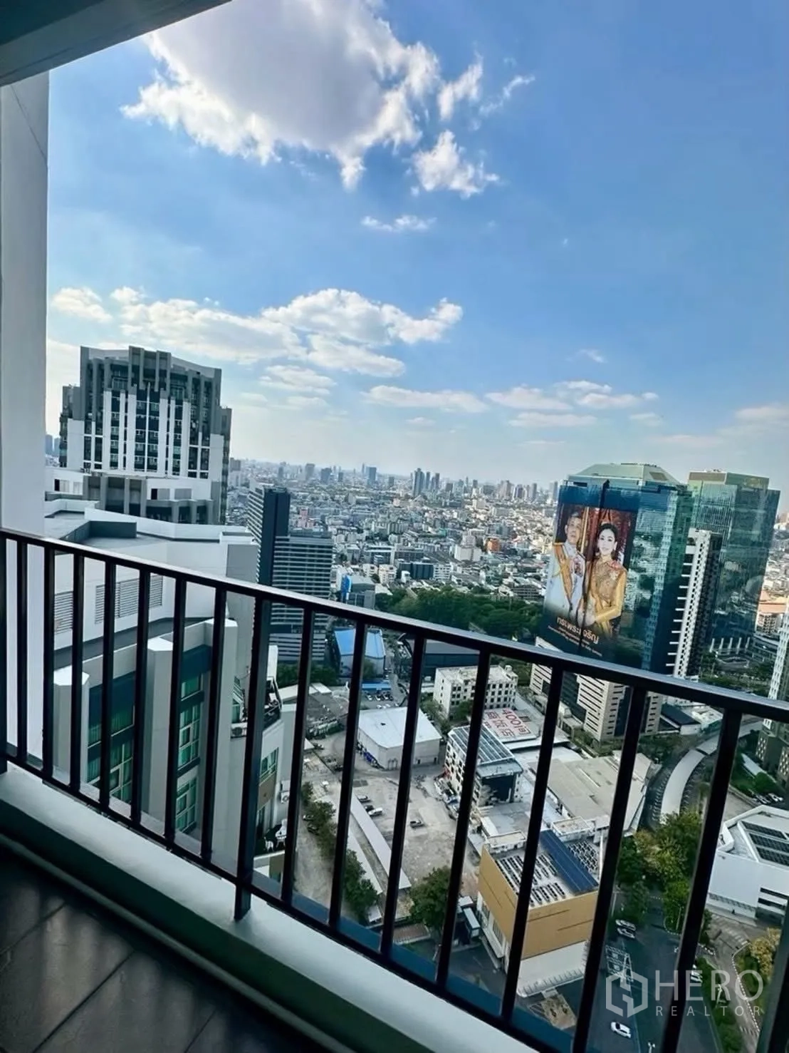 Condominium for rent in Huai Khwang, Bangkok - Private balcony with railing overlooking Bangkok skyline.