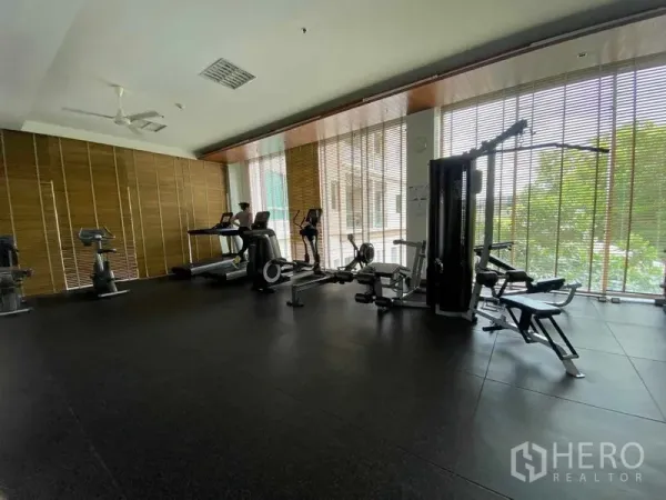 Condominium for rent in Yan Nawa, Bangkok - Condominium fitness room featuring treadmills, bikes, and weight machines along floor-to-ceiling windows.