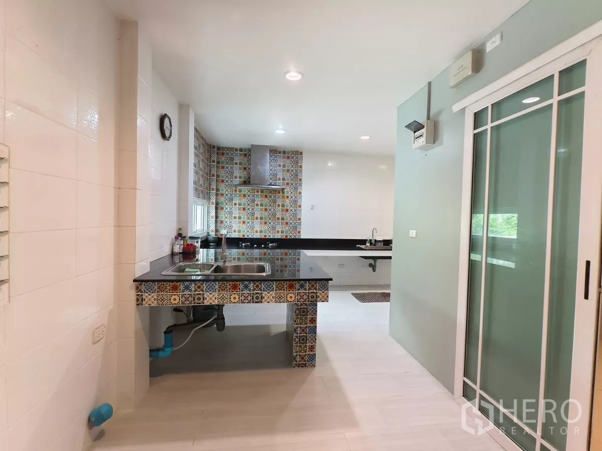 Detached House for rent in Bang Kapi, Bangkok - Large Thai kitchen with colorful tiled island and twin sinks.