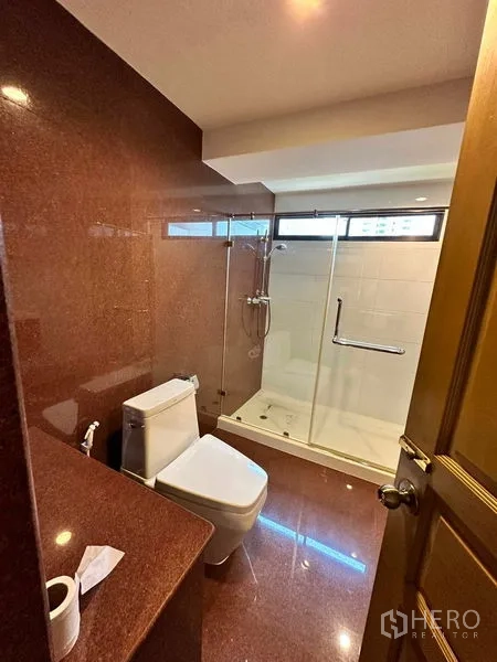 คอนโด ให้เช่าในBangkok - ห้องน้ำพร้อมตู้กระจกอาบน้ำ สุขภัณฑ์สีขาว และผนังโทนหินอ่อน