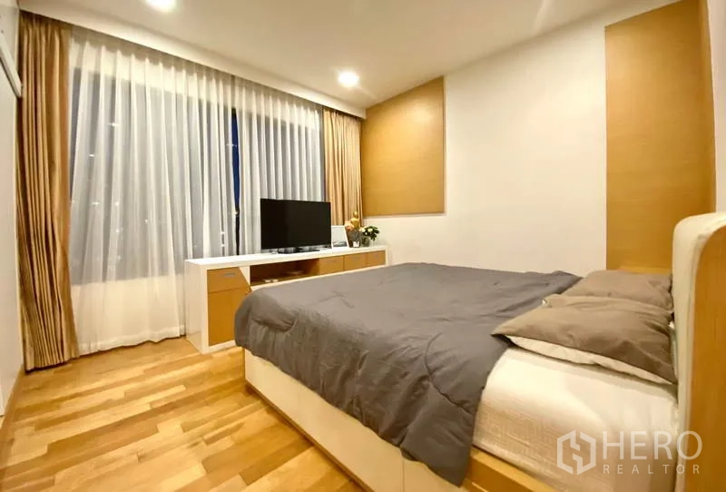 คอนโด ให้เช่าหรือขายในKhlong Toei, Bangkok - ห้องนอนอบอุ่น เตียงนอน ชั้นวางทีวี ม่านโปร่ง และแสงไฟโทนอุ่น