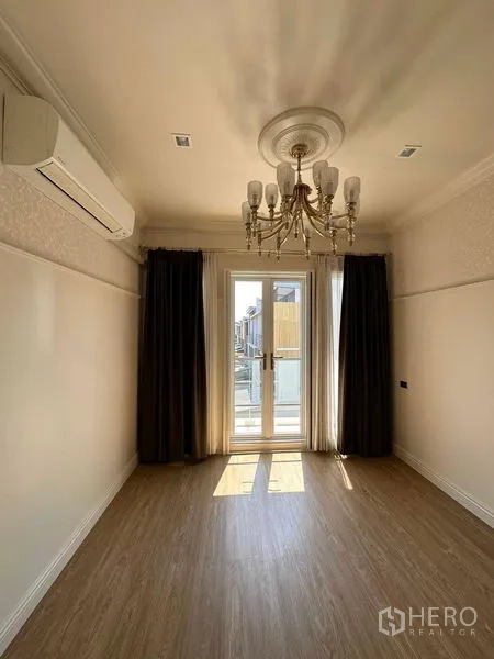 ทาวน์เฮาส์ ขายในLat Phrao, Bangkok - ห้องตกแต่งด้วยโคมระย้า มีแอร์ และประตูฝรั่งเศสเปิดสู่ระเบียง