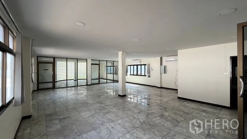 Warehouse for rent in Thanyaburi, Pathum Thani - Large office workspace with windows, glass partitions, and tiled floors.