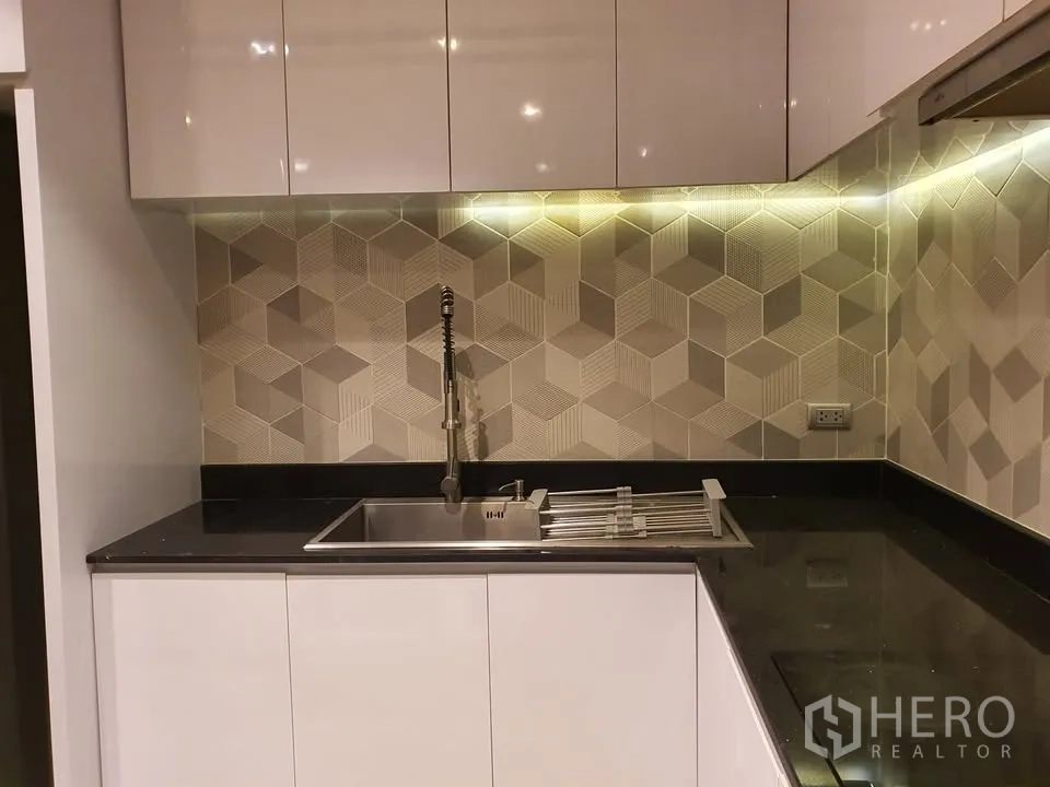 คอนโด for rent in Watthana, Bangkok - ภาพระยะใกล้อ่างล้างจานครัว ไฟใต้ตู้ และกระเบื้องผนังลายเรขาคณิต