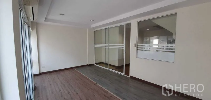 带办公室的家 出租在Prawet, Bangkok - 前部房间，带推拉玻璃墙与窗户，配空调和木地板。