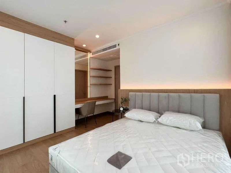 คอนโด ให้เช่าในWatthana, Bangkok - ห้องนอนหลัก หัวเตียงบุนวม ตู้เสื้อผ้าขนาดใหญ่ โต๊ะทำงาน และไฟซ่อนนุ่มนวล
