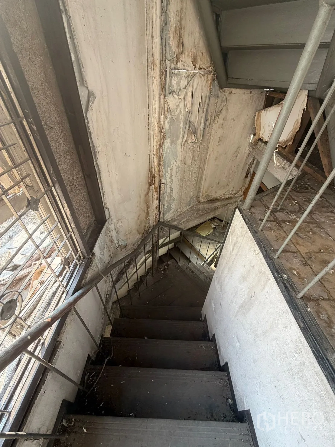 Shophouse for rent in Watthana, Bangkok - Narrow staircase descending beside a large window.