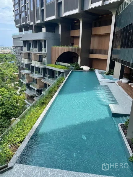 Condominium for rent in Samut Prakan - Elevated infinity swimming pool along the facade with treetop and city views.