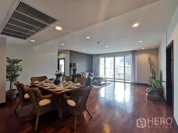 คอนโด ให้เช่าหรือขายในKhlong Toei, Bangkok - โถงนั่งเล่นและรับประทานอาหารแบบโอเพ่นสเปซ พื้นไม้ เซ็ตโต๊ะหวาย และหน้าต่างบานกว้างเห็นระเบียงวิวเมือง