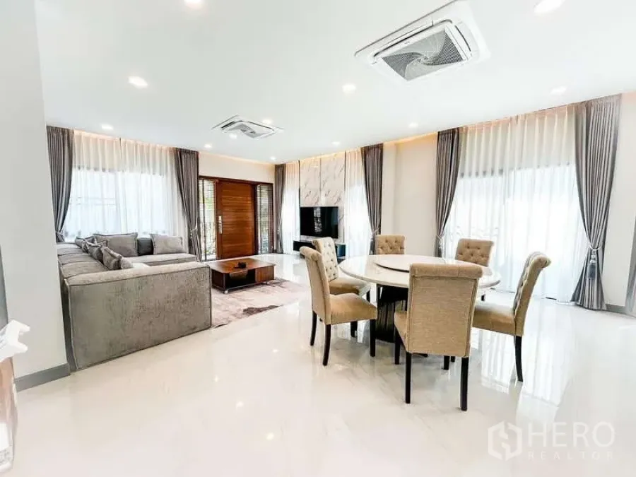 Detached House for rent in Bang Phli, Samut Prakan - Bright dining space with round table for six, opening to a spacious living room with big windows.