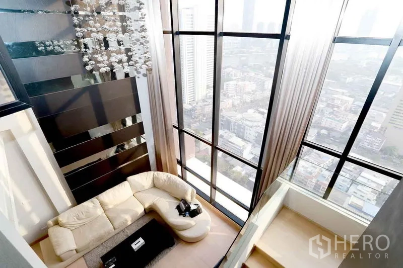 คอนโด ให้เช่าในKhlong San, Bangkok - ห้องนั่งเล่นเพดานสูงพร้อมหน้าต่างสูงจรดเพดาน มองเห็นวิวสกายไลน์