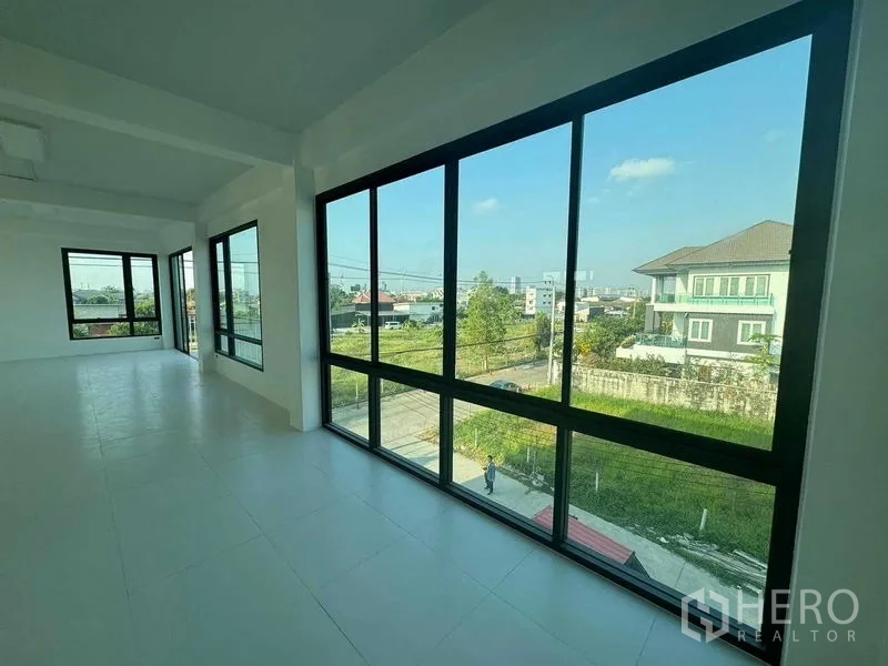 Home Office for rent in Don Mueang, Bangkok - Upper-floor workspace with floor-to-ceiling corner windows overlooking the neighborhood.