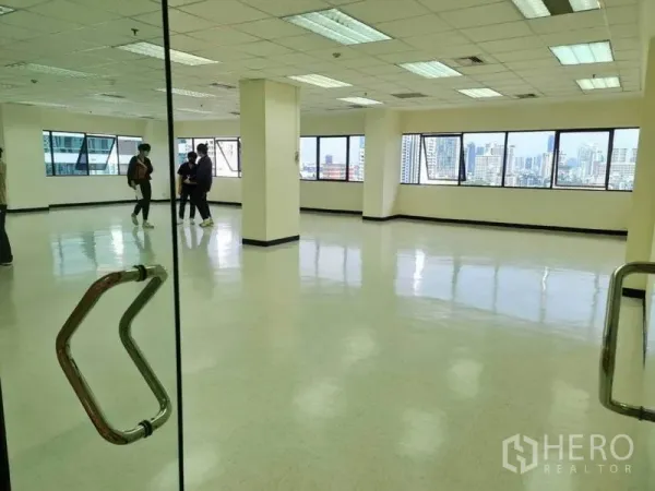 Office Space for rent in Watthana, Bangkok - Corner office floor with panoramic windows, polished floors and suspended fluorescent lighting.