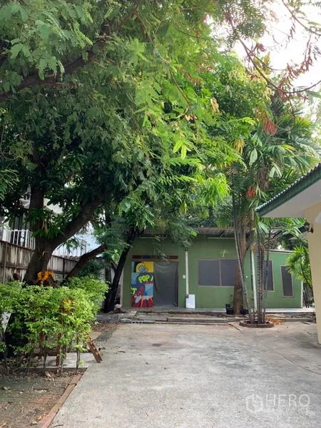 Detached House for rent in Khlong Toei, Bangkok - Long driveway with mature trees and a separate outbuilding at the rear.
