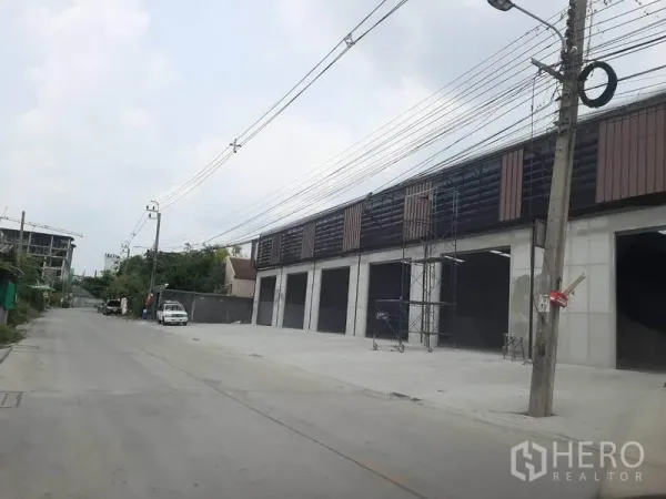 Warehouse for rent in Nonthaburi - Street view of warehouse complex with wide driveway, several bay openings, and truck-friendly access.