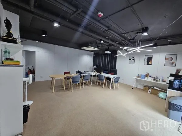 零售空间 出租 - 宽敞办公室式房间，现代灯具、白色隔墙与会议桌。