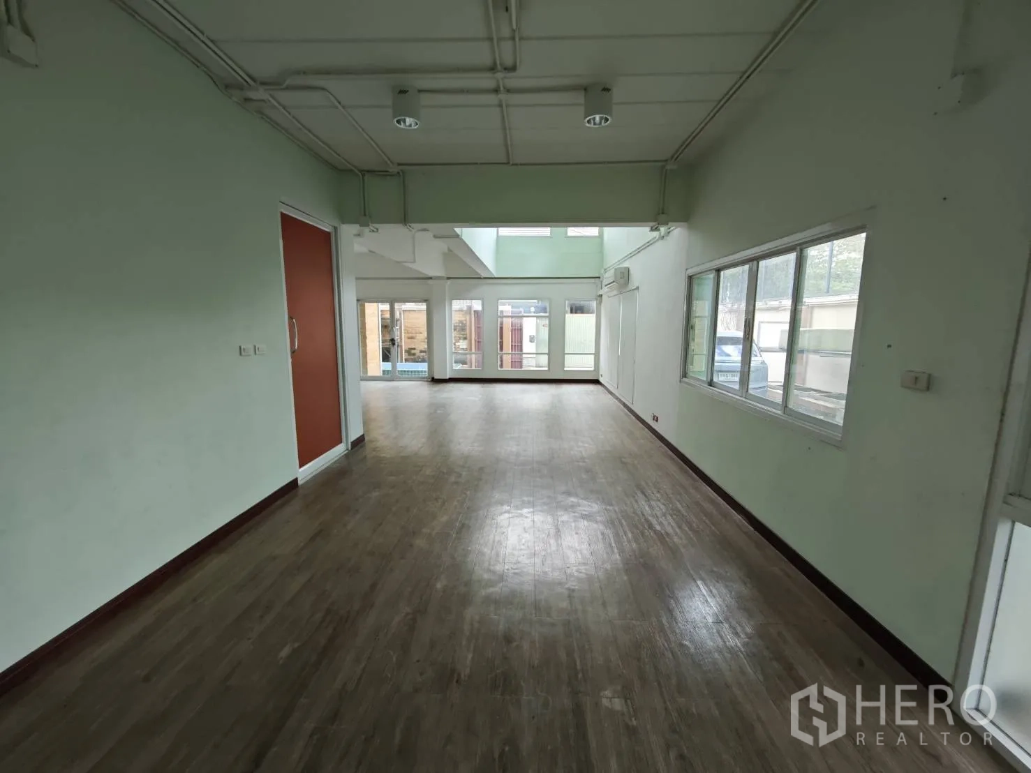 Office Space for rent in Prawet, Bangkok - Open-plan office area with wood flooring, large windows and sliding doors.