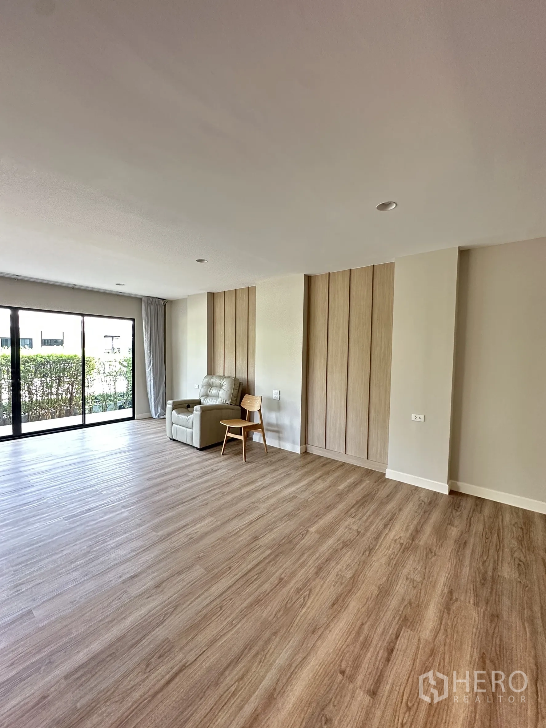 บ้าน ขายในLam Luk Ka, Pathum Thani - ห้องอเนกประสงค์ชั้นล่าง พื้นลายไม้ ประตูเลื่อนมองเห็นสวน