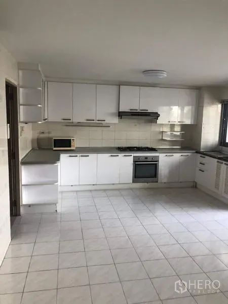 อพาร์ทเมนท์ ให้เช่าในWatthana, Bangkok - ครัวบิวท์อินโทนขาวรูปตัวแอล มีเตาแก๊ส เตาอบ ไมโครเวฟ และพื้นกระเบื้อง