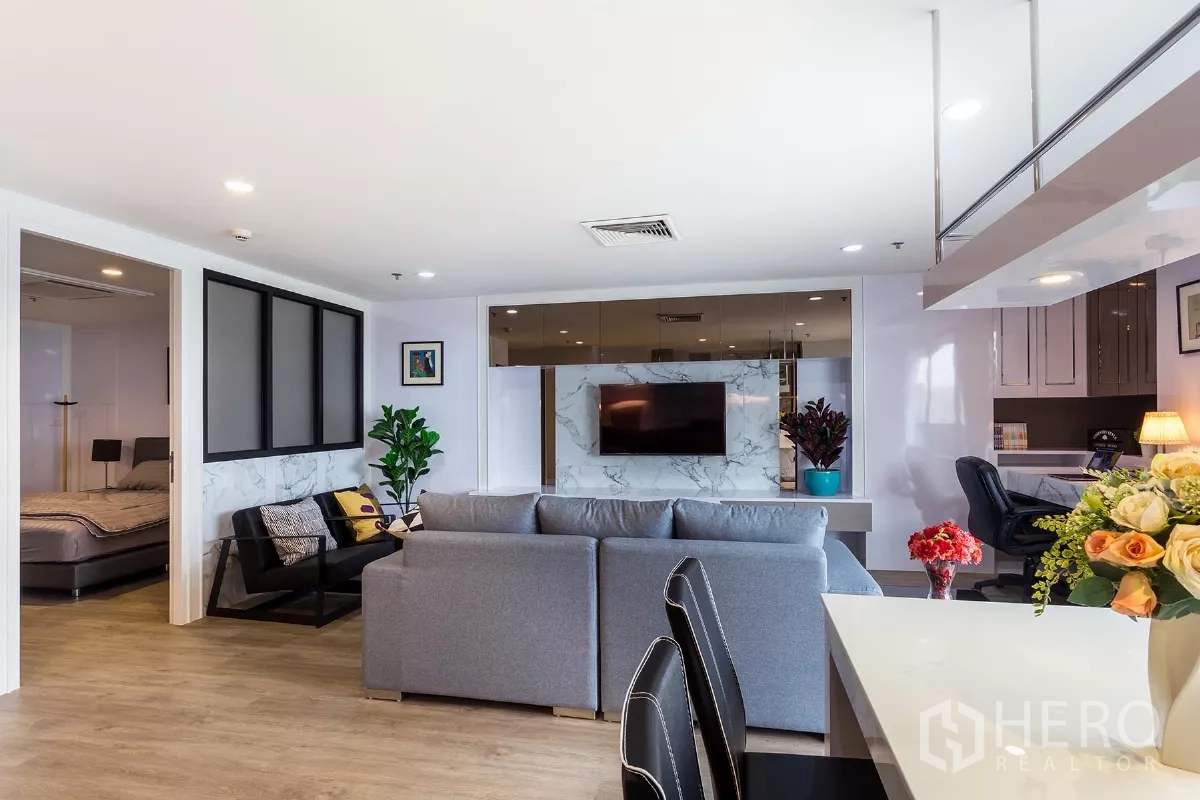 Condominium for rent or sale in Watthana, Bangkok - Spacious living area facing the TV wall with doorway to the bedroom and a study corner.