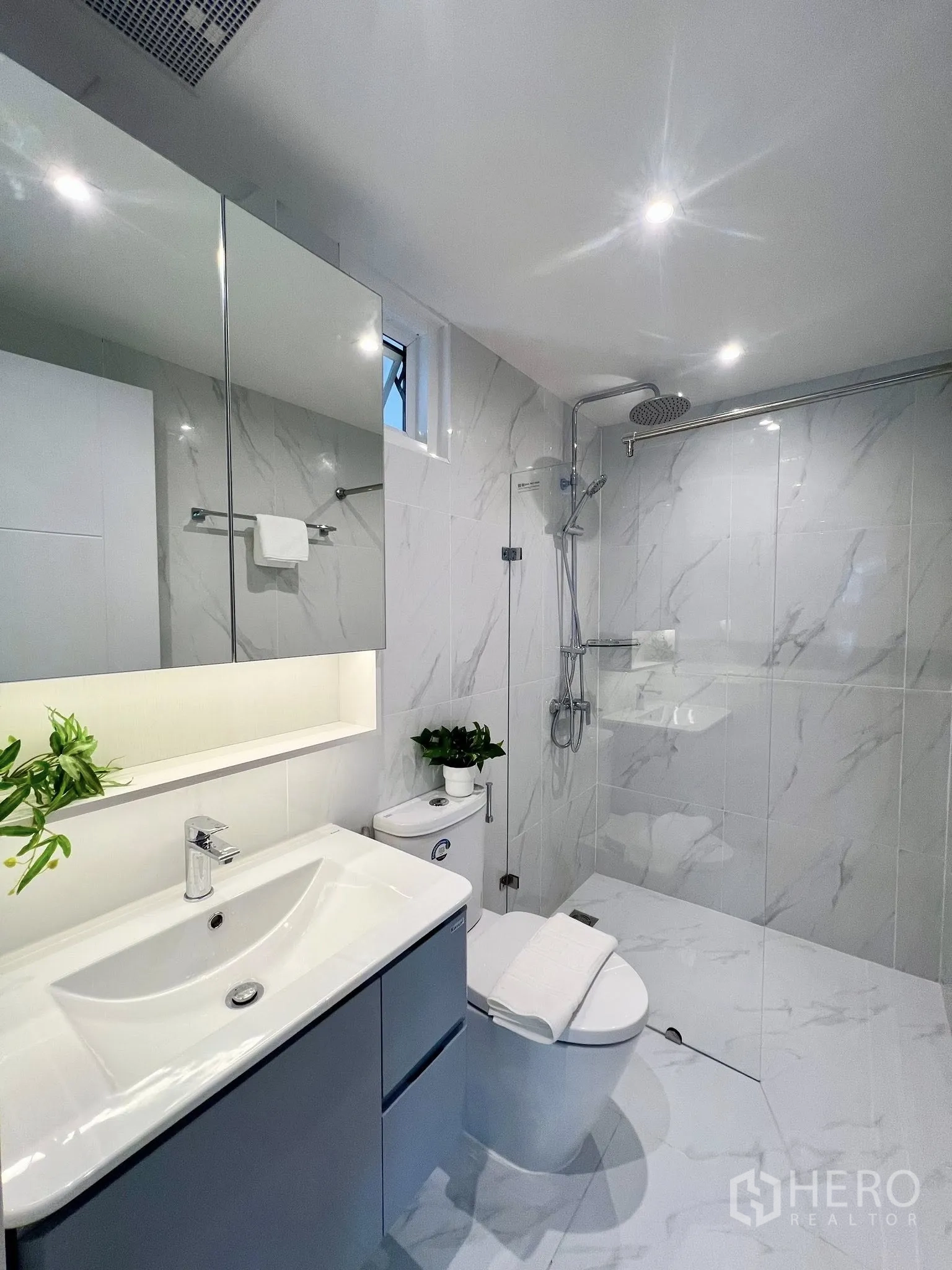 Condominium for rent or sale in Yan Nawa, Bangkok - Contemporary bathroom with marble-look tiles, rain shower, mirrored cabinet and modern fixtures.