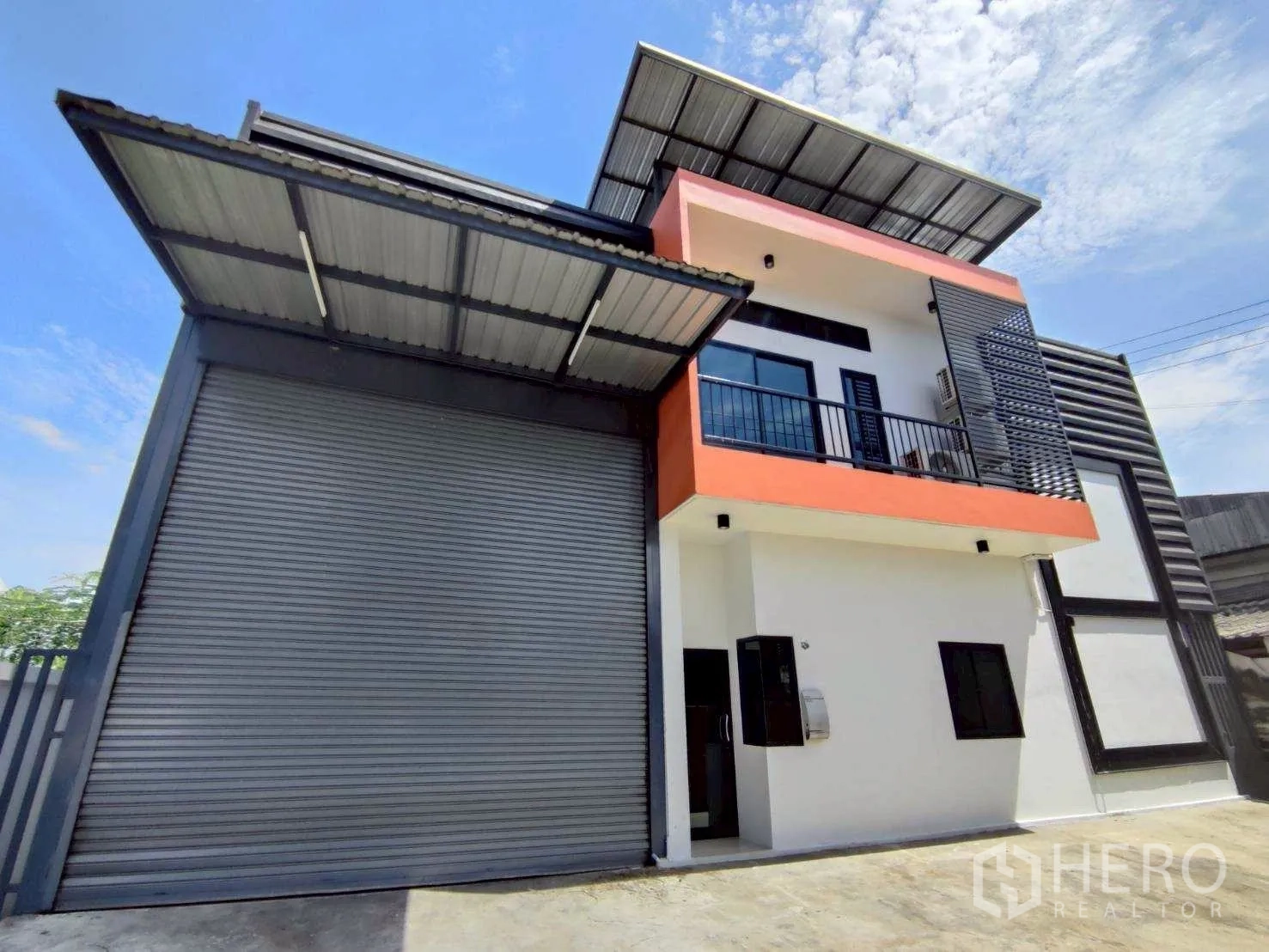 โกดัง for rent in Lam Luk Ka, Pathum Thani - มุมหน้าอาคารพร้อมระเบียงสำนักงานเหนือประตูโหลดสินค้า.