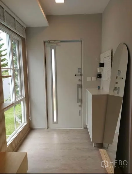 Detached House for rent in Prawet, Bangkok - Entry foyer with glass-paneled front door, console cabinet, full-height mirror, and picture window.