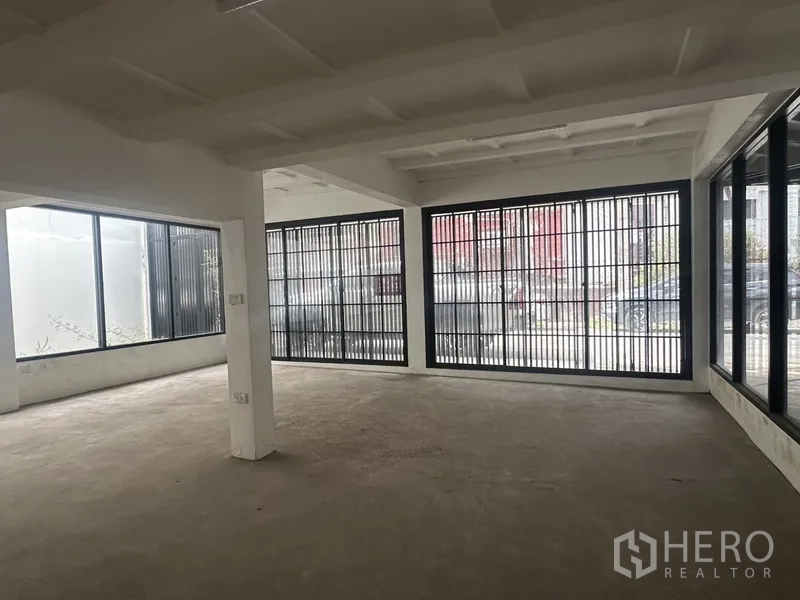 带办公室的家 出租或出售在Bang Na, Bangkok - 明亮转角空间，整面落地窗与金属格栅。