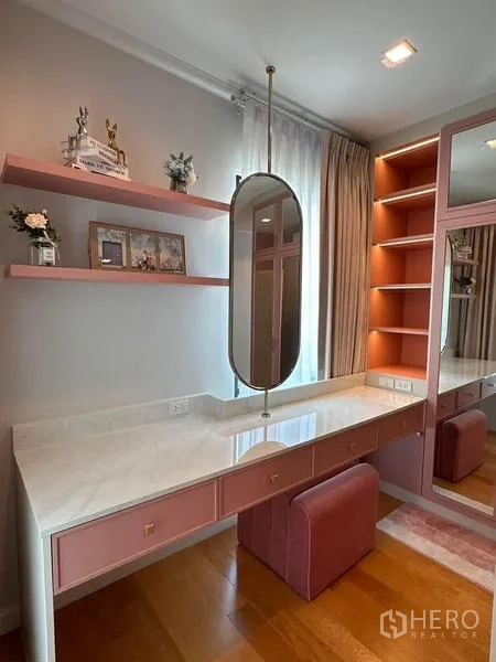 独立式住宅 出租在Prawet, Bangkok - 粉色梳妆区，大理石台面与椭圆镜和置物架。