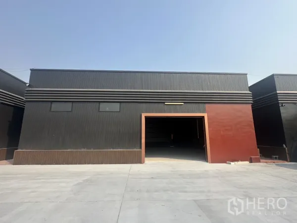 货栈 出租在Prawet, Bangkok - 曼谷Prawet现代黑色仓库外立面，宽阔车辆入口与大型混凝土前院。