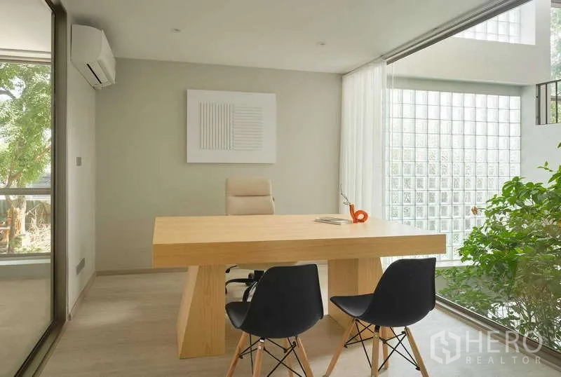 Home Office for sale in Chatuchak, Bangkok - Minimalist executive office with large wooden desk, glass‑block wall, indoor plant and natural light.