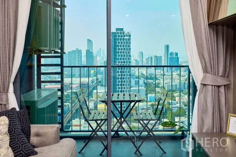 Condominium for rent in Phra Khanong, Bangkok - Balcony with bistro set overlooking the Bangkok skyline and BTS tracks.