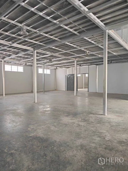 Warehouse for rent in Krathum Baen, Samut Sakhon - Spacious open-plan warehouse floor with steel ceiling and support columns.