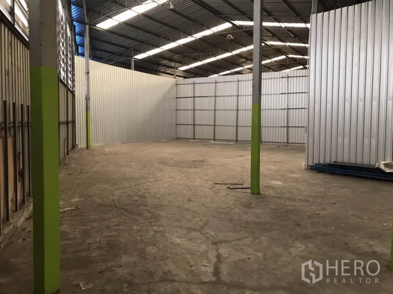 คลังสินค้า ให้เช่าในBang Na, Bangkok - พื้นที่โกดังโล่ง เพดานสูง เสารองรับทำสีเขียว พร้อมผนังกั้นเมทัลชีทด้านข้าง