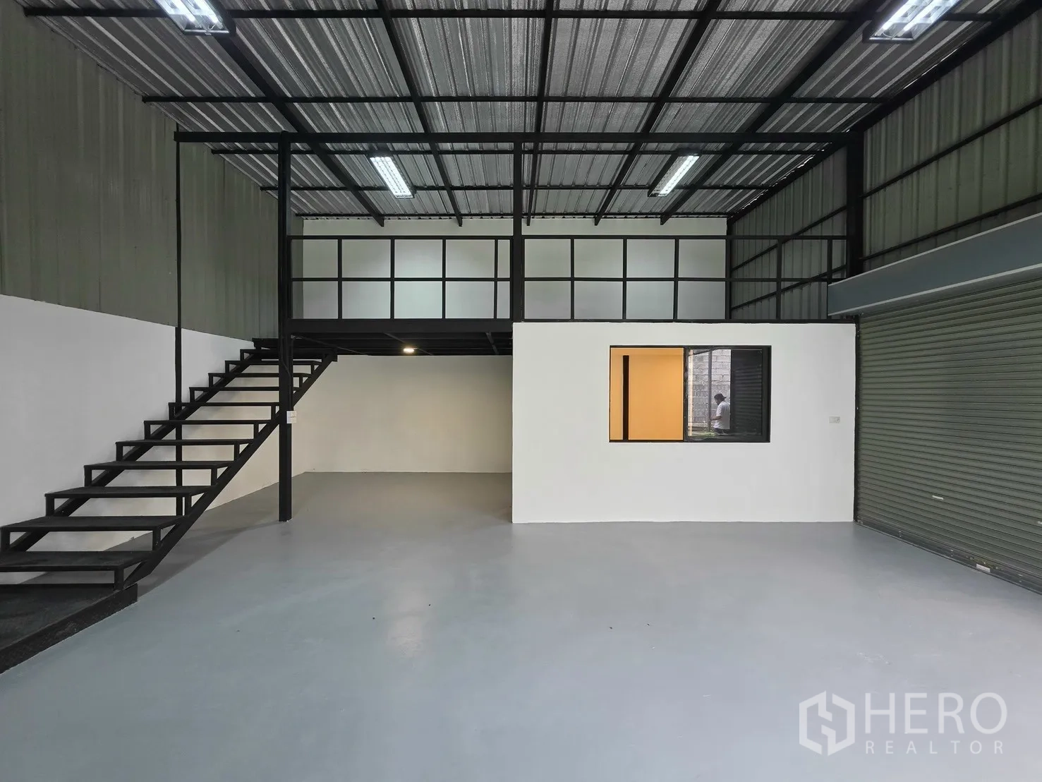 Warehouse for rent in Suan Luang, Bangkok - Warehouse interior showing mezzanine, steel stairs, and an internal window.