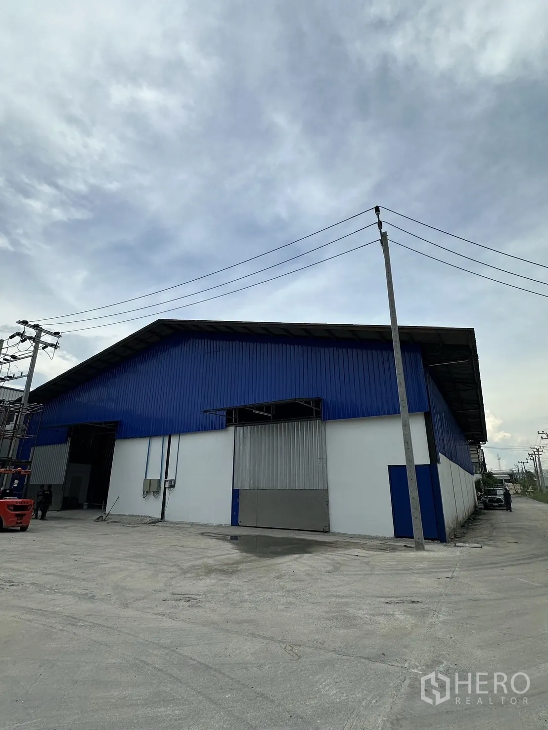 仓库 for rent in Mueang Samut Prakan, Samut Prakan - 仓库外观，设有大型滑门与宽阔混凝土场地。