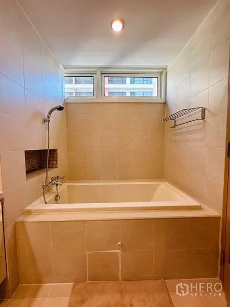 公寓 出租在Bang Rak, Bangkok - 深浸式浴缸，带手持花洒与高窗，墙面全瓷砖。