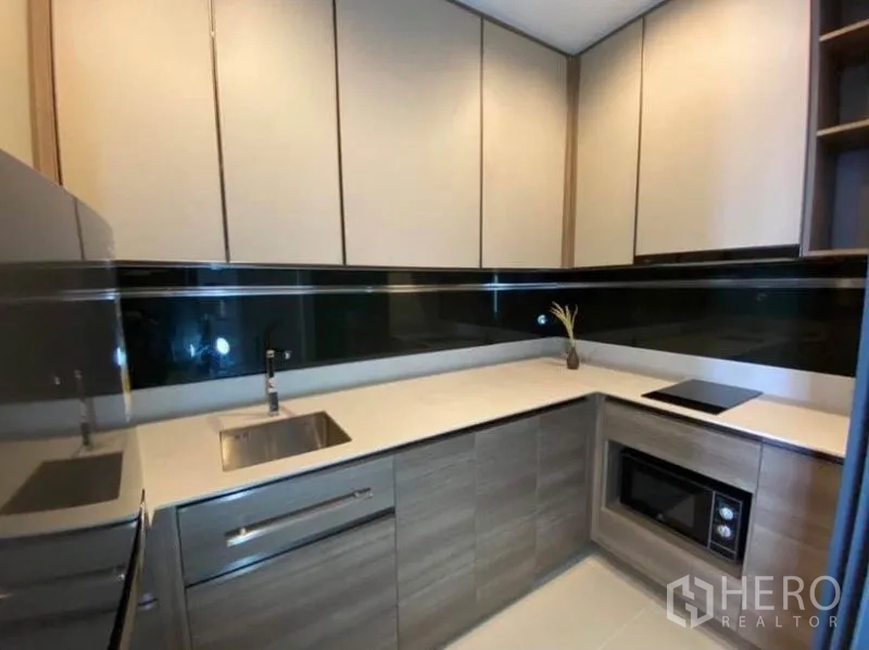 公寓 出租或出售在Phaya Thai, Bangkok - U 型厨房，顶柜、水槽、电磁炉与微波炉齐备。