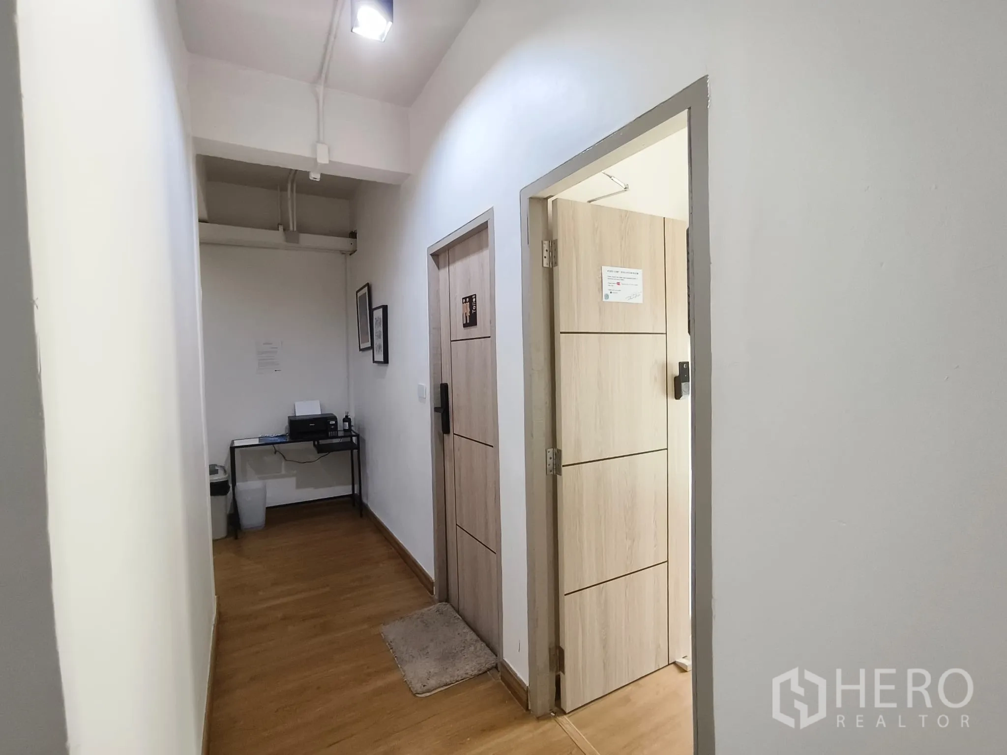 ตึกแถว for rent in Watthana, Bangkok - โถงทางเดินพื้นไม้สีอ่อนและประตูไปยังห้องต่างๆ.