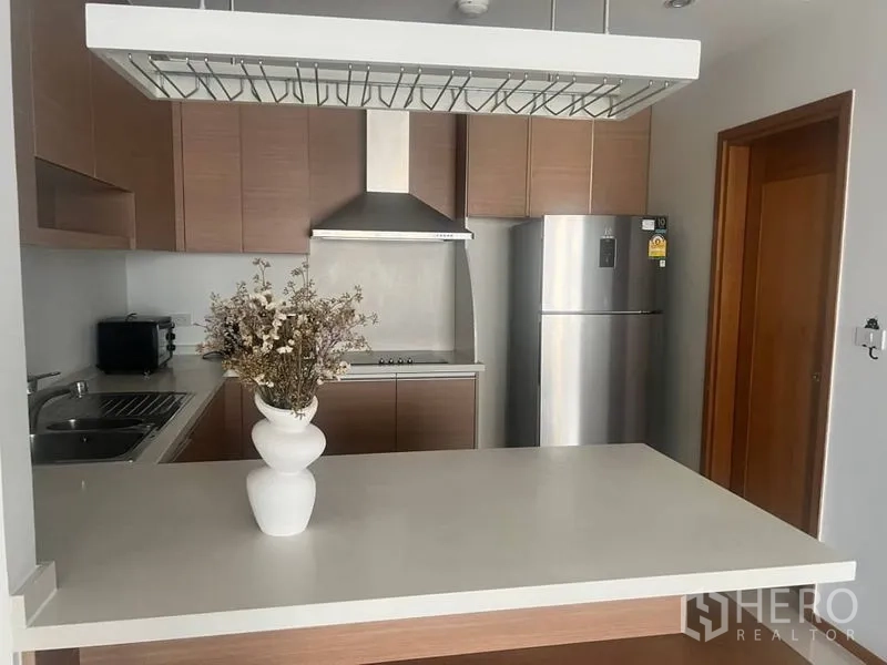 คอนโด ให้เช่าในBangkok - ครัวบิวท์อินสไตล์โมเดิร์น ตู้ไม้ เครื่องดูดควัน ตู้เย็นสแตนเลส และไอส์แลนด์สีขาว